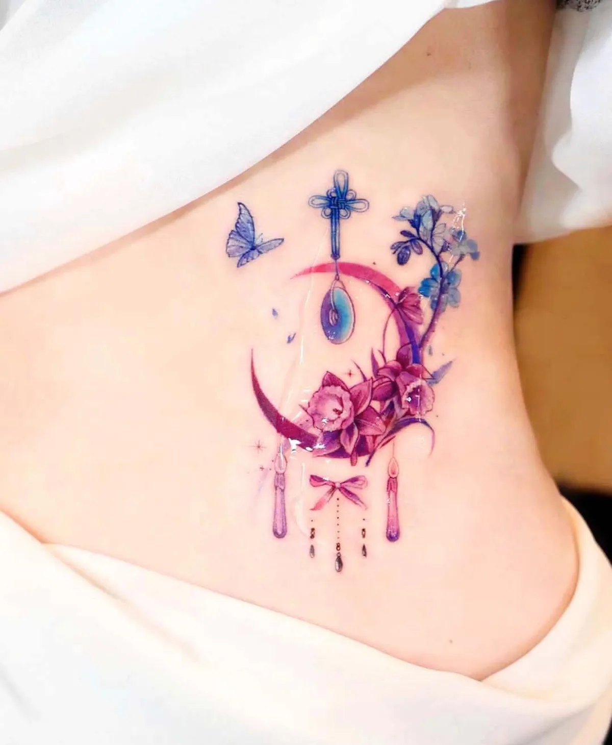 rosa traumfänger halbmond tattoo mit blauen schmetterlingen