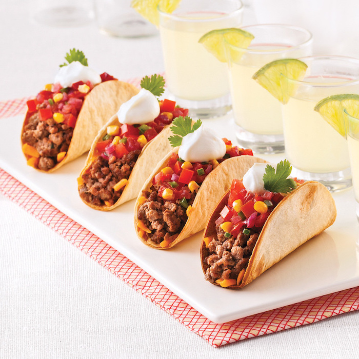 Tacos mit Rindfleisch, roter Paprika und Mais, garniert mit Mayonnaise Sauce und frischer Petersilie 