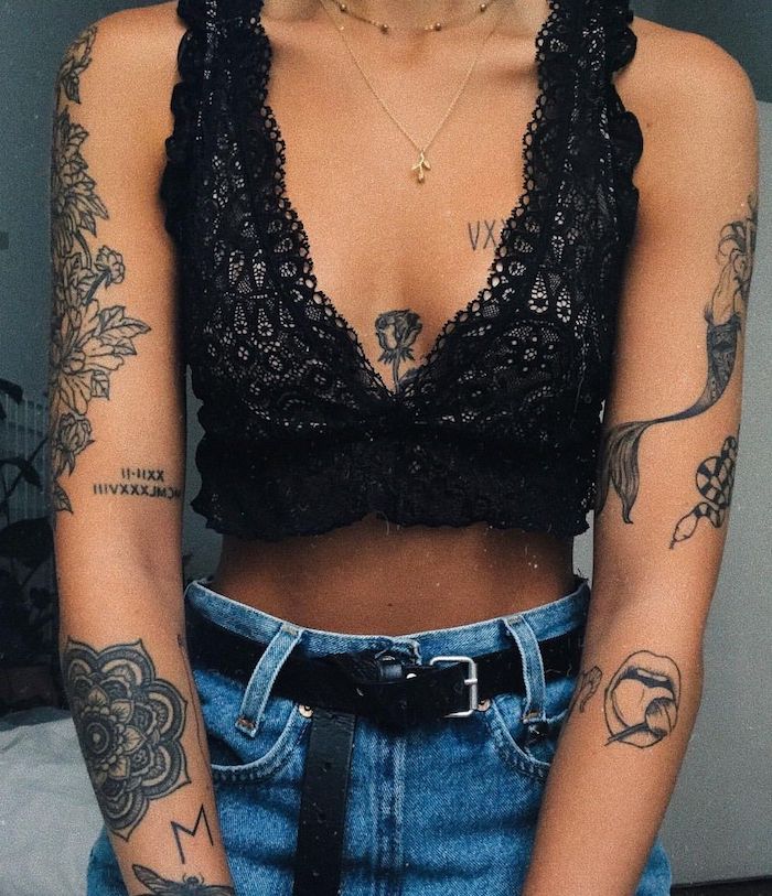 Tattoos an beiden Armen, Mandala Blume, Mond mit Lutscher, Meerjungfrau Tattoo, Schlange und Rose, schwarzes kurzes Top und Jeans mit hoher Taille 