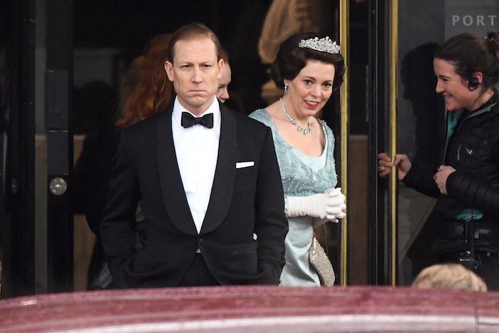 eine königin mit einer großen weißen krone und einer halskette und blauem kleid, mann mit kostüm, the crown von netflix