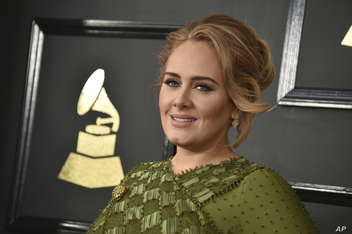 Adele beim Vergeben von Emmy Preise mit dem Symbol im Hintergrund
