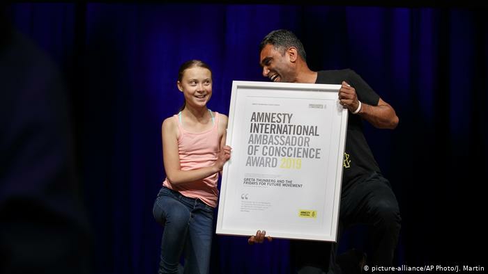 Greta trägt ein rosa Hemd und Jeans, sie bekommt den Amnesty-Preis
