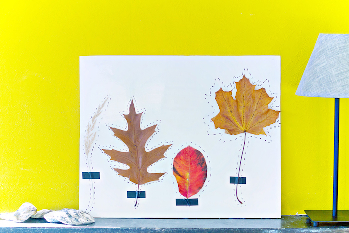 Herbstliche Dekoration mit Kindern basteln, bunte Herbstblätter auf Papier kleben 