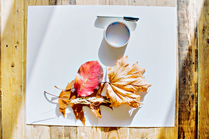 Materialien für Herbstbasteln, bunte Herbstblätter, weißes Papier, Klebeband und Filzstift 