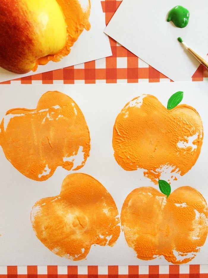 Stempel aus halbiertem Apfel selber machen, Halloween Kürbisse mit Kindern malen 