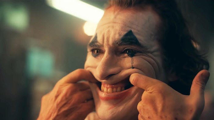 Joker, der schauspieler joaquin phoenix in der rolle des jokers, ein mann mit einer weißen schminke eines clownes