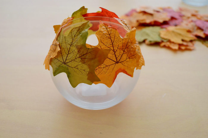 Herbstliches Teelicht selber machen, rundes Glas mit künstlichen Herbstblättern dekorieren 