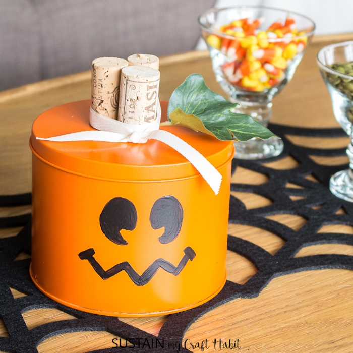 DIY Halloween Box für Leckereien, verziert mit drei Korken, weißer Schleife und künstlichem Blatt