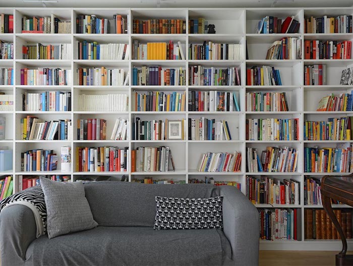 Harmonie bestimmt die Wohntrends von heute, graues Sofa, weiße Regale, viele Bücher