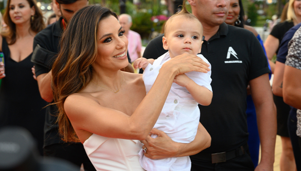 Eva Longoria trägt ihr kleiner Sohn Santiago, beiden sind in weiß gekleidet