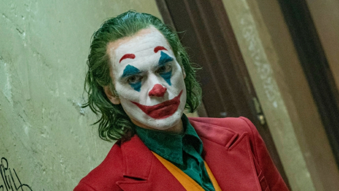 Joker, weißes Gesicht, roter Mantel, grünes Hemd, ein Serienmörder wie Clown