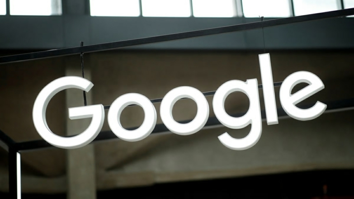 Google Logo mit weißen Buchstaben auf einem Brett in Werkhaus gehängt