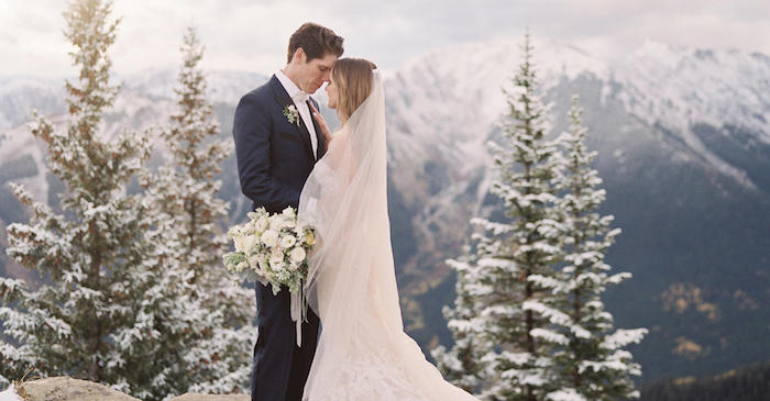 Hochzeit als Wintermärchen, Hochzeitspaar im Wald, Bäume bedeckt mit Schnee im Hintergrund