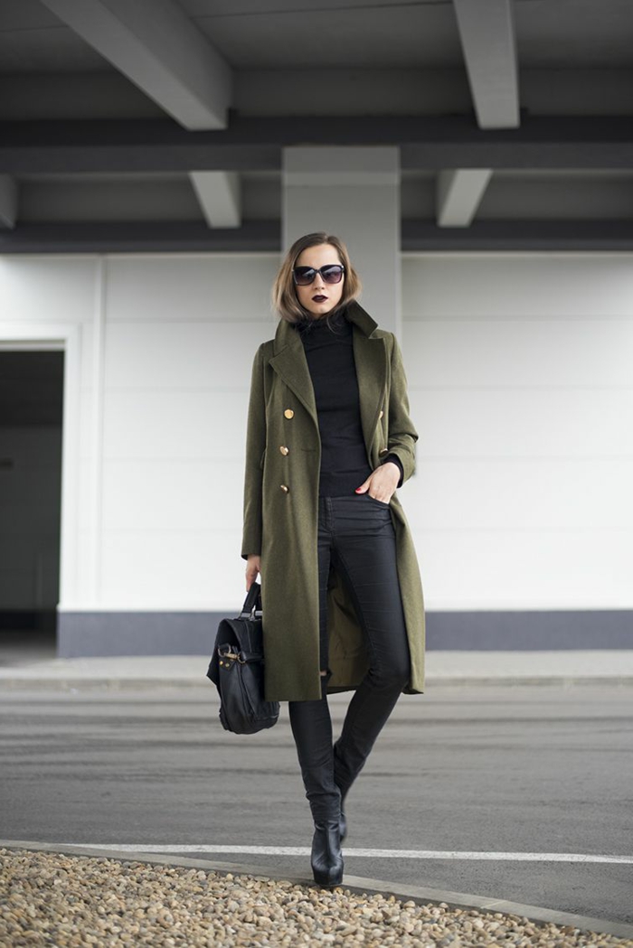 Elegante Dame mit grünem Mantel, schwarze Hosen, Handtasche aus Leder, Stiefeln mit Absatz, kleiderordnung casual