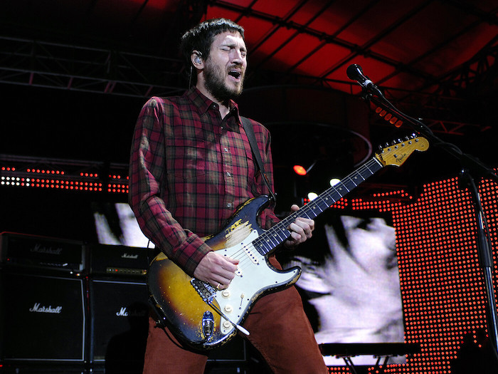 ein gitarrist, der auf der bühne spielt, mann mit gitarre und einem roten hemd, john Frusciante kehrt zu der band red hot chili peppers zurück