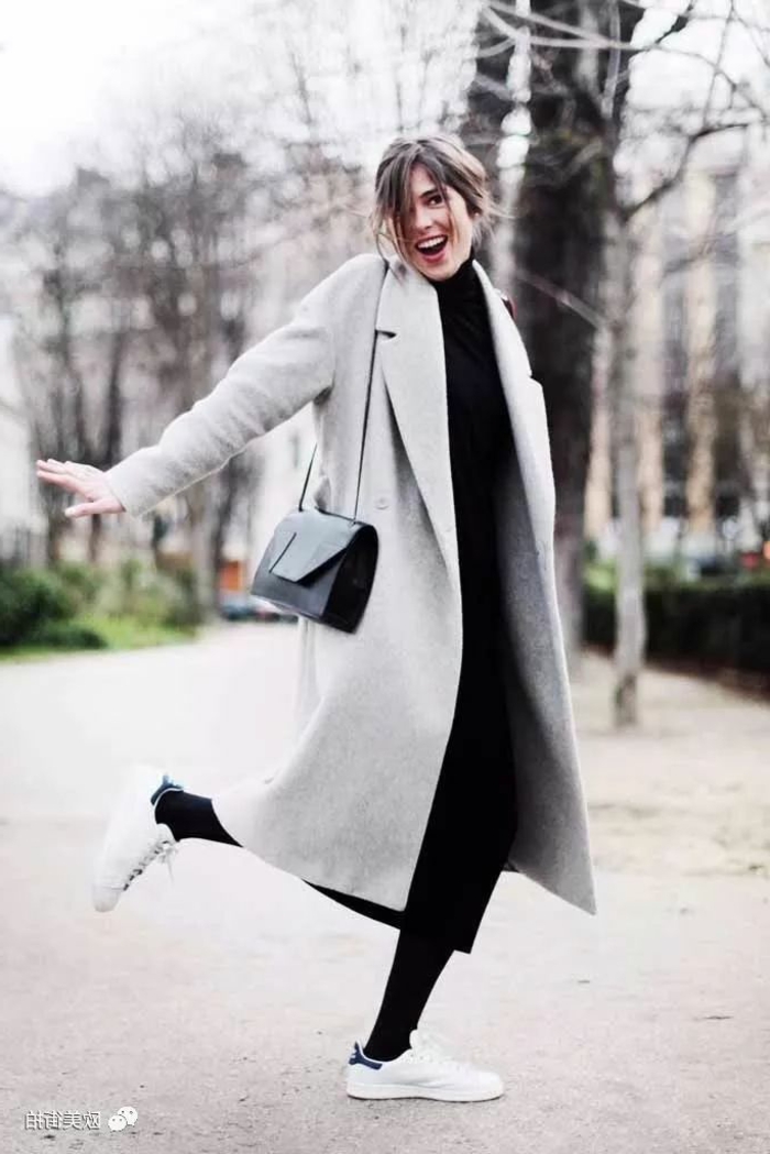 Lässig angezogene Dame mit langem Mantel, schwarzer Pullover, weißen Schuhen