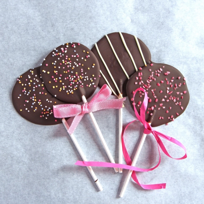 kochen mit kindern, einfache lutscher aus schokolade dekroiert mit rosa schleifen