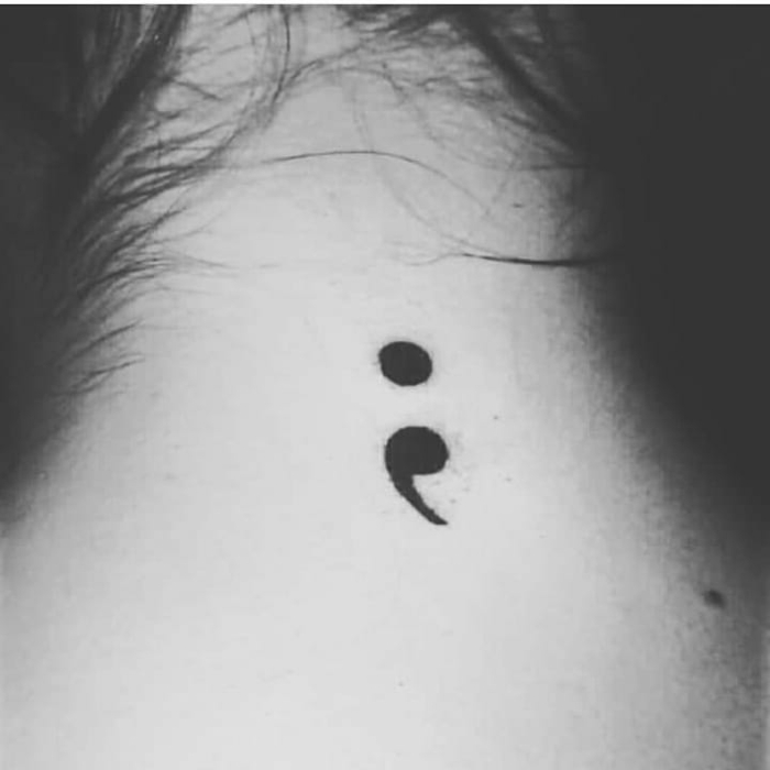 Schwarzes Semicolon Tattoo am Nacken, hochgesteckte Haare, was bedeutet ein semikolon