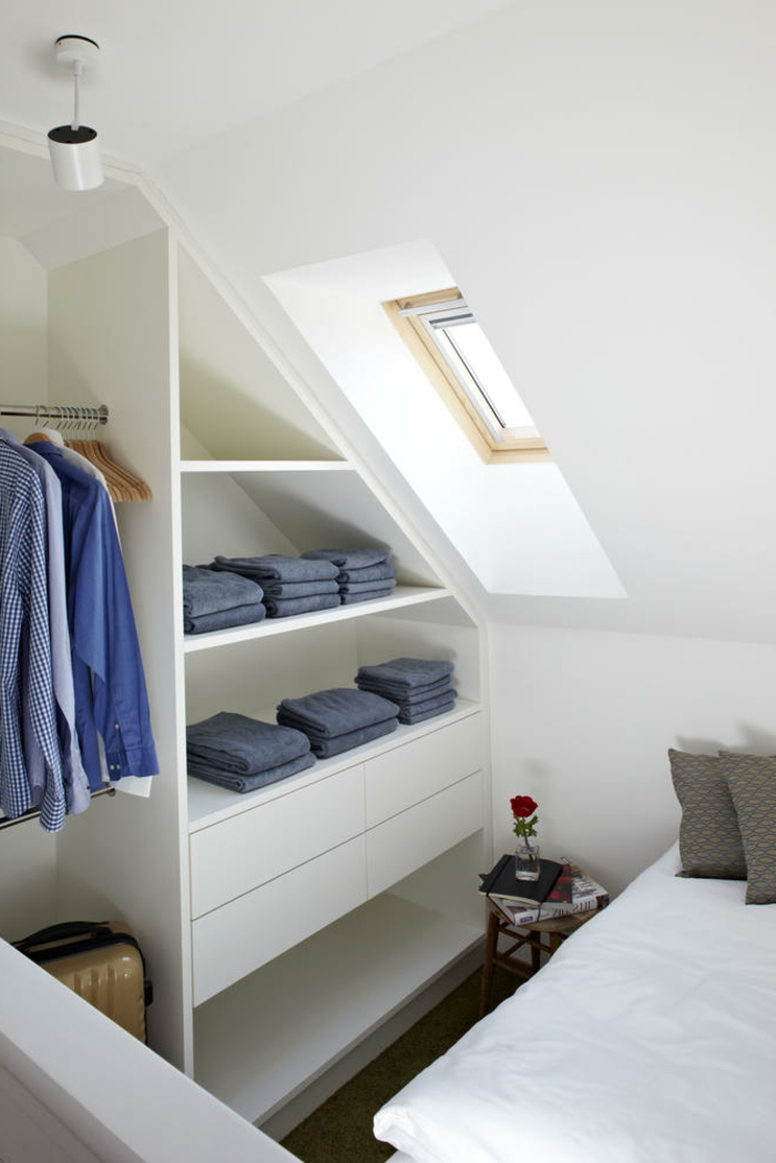 Kleines Schlafzimmer, Einrichtung begehbarer Kleiderschrank Dachschräge mit kleinem Fenster, gefaltete Jeans