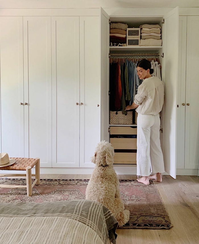 Kleiderschrank mit Türen, Ankleidezimmer Ideen Ikea, bunter Teppich, Frau im weißen Outfit, großer flauschiger Hund