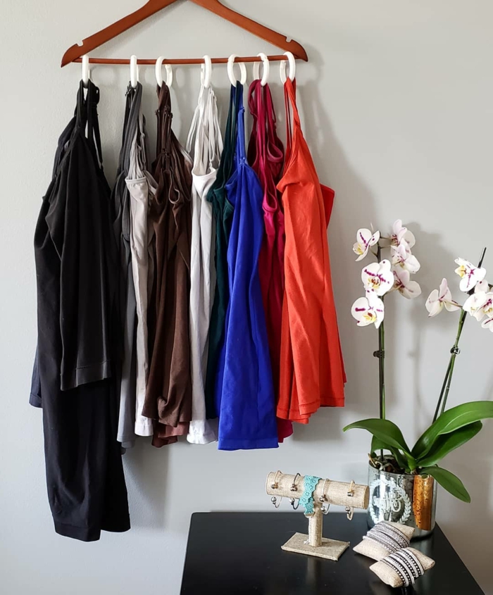 Tops in rot blau braun und schwarz aufgehängt an eine Kleiderbügel, Ankleidezimmer planen Tipps, weiße Orchidee