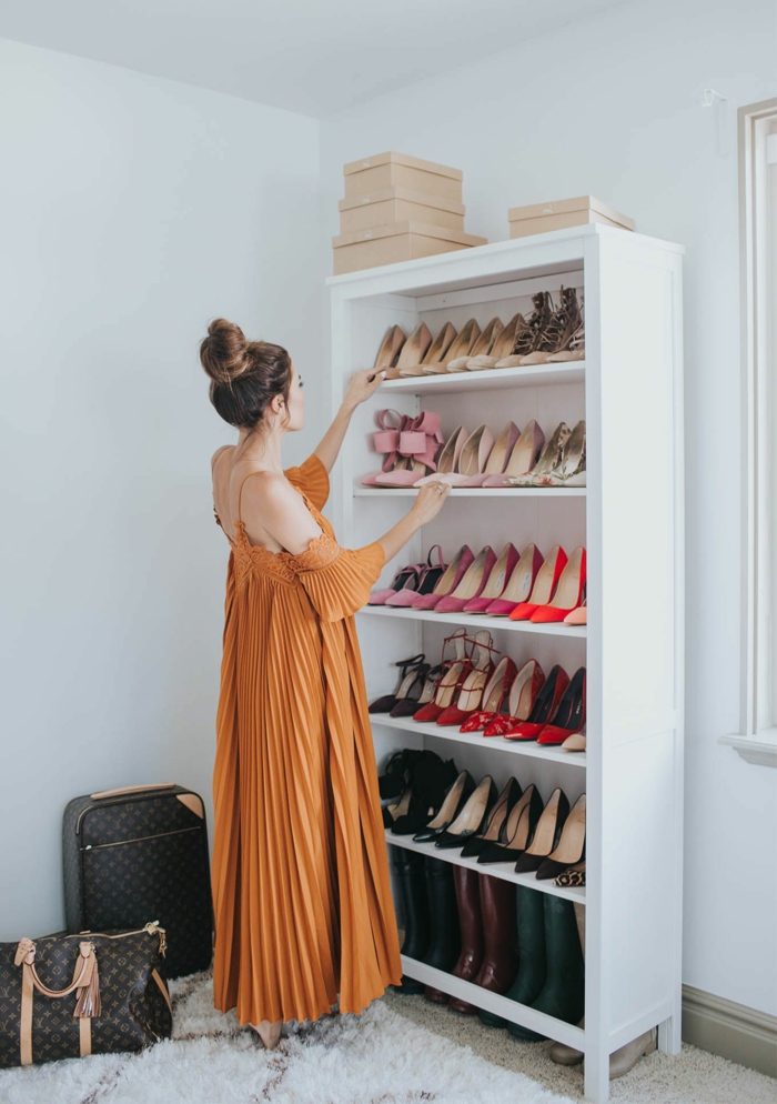 Elegante Frau im langen stylischen ocker Kleid mit hochsteck Frisur vor einem Schuhschrank, Ankleidezimmer einrichten