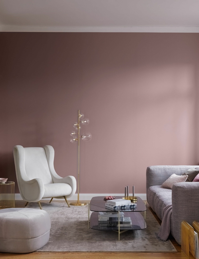 Moderne Ausstattung eines großen Wohnzimmers, passende Farbe zu rosa, weißer Sessel und Couch in grau, dunkle pastellfarbene Töne
