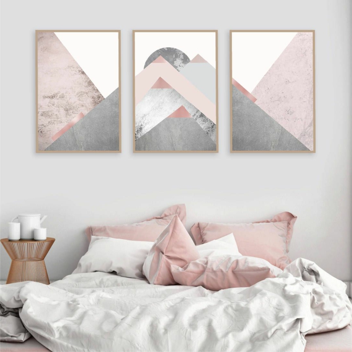 Schlafzimmer grau rosa, drei Bilder mit geometrischen Figuren in grau und rosa, weiße Bettwäsche und rosa Kissen, hellgraue Wand