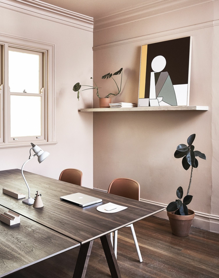 Mischfarben für Wände in rosa und grau, Schreibtisch mit einem Laptop obendrauf, angelehntes geometrisches Bild, mittelgroße grüne Blume