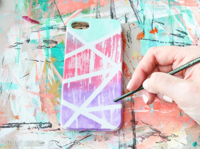 Bunte Handyhülle selbst gestalten in pink, lila und blassgrün, Hand malt vertikale Streifen, bunter Hintergrund