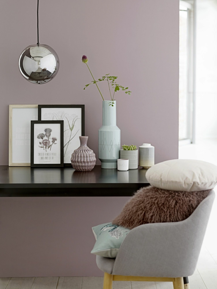 Schlafzimmer altrosa, Stuhl in grau mit Kissen in weiß und braun, schwarzer Tisch mit Bildern obendrauf, Wandfarbe altrosa