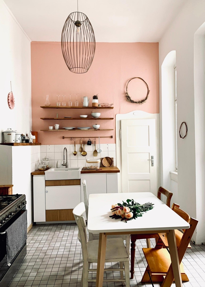 Wandfarbe Inspiration altrosa für kleine Küche, Ofen in schwarzer Farbe, weißer rechteckiger Tisch, attraktive Pendelleuchte, hängender Kranz über die Tür