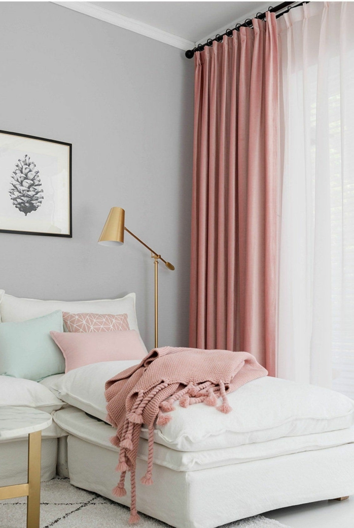 Wohnzimmer grau rosa, Gardinen und Decke in altrosa, Lampe in goldener Farbe, großes Ecksofa in weißer Farbe, schwarz weißes Bild von einem Zapfen,