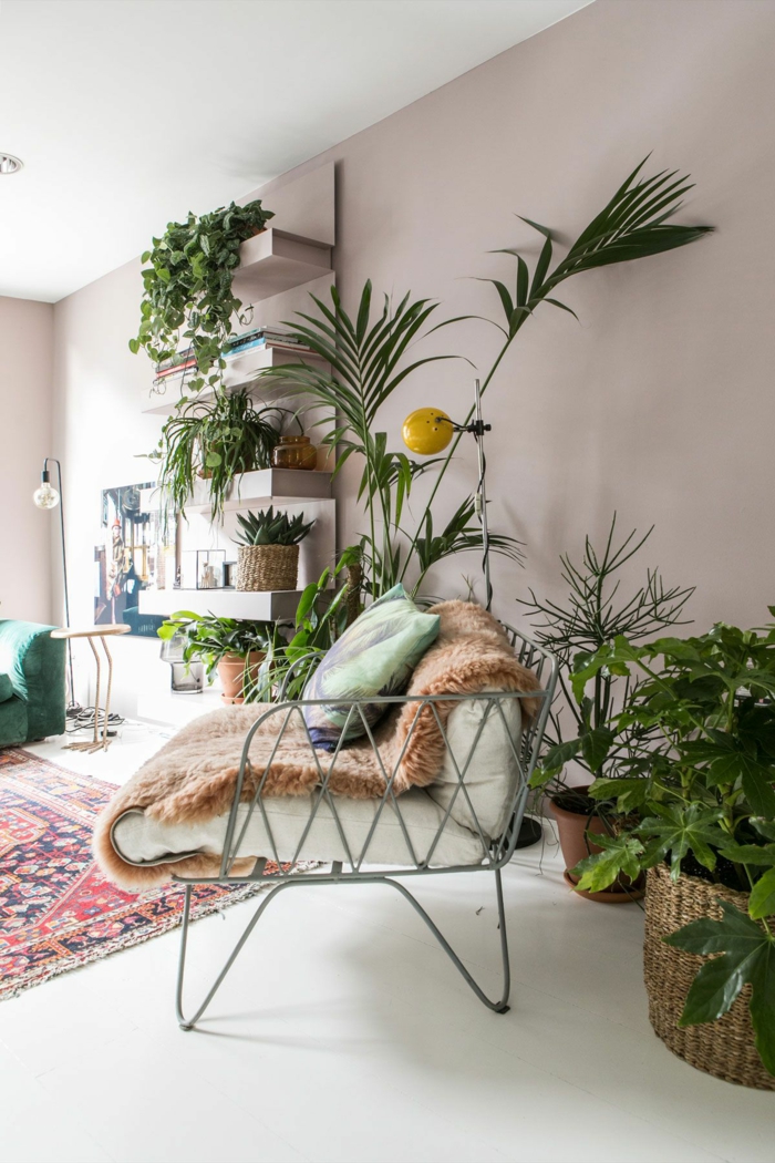 Dekoration mit vielen grünen Pflanzen, Wohnzimmer altrosa, Farbe für Wand, bunter Teppich mir roten Schattierungen, Couch und Kissen in grün