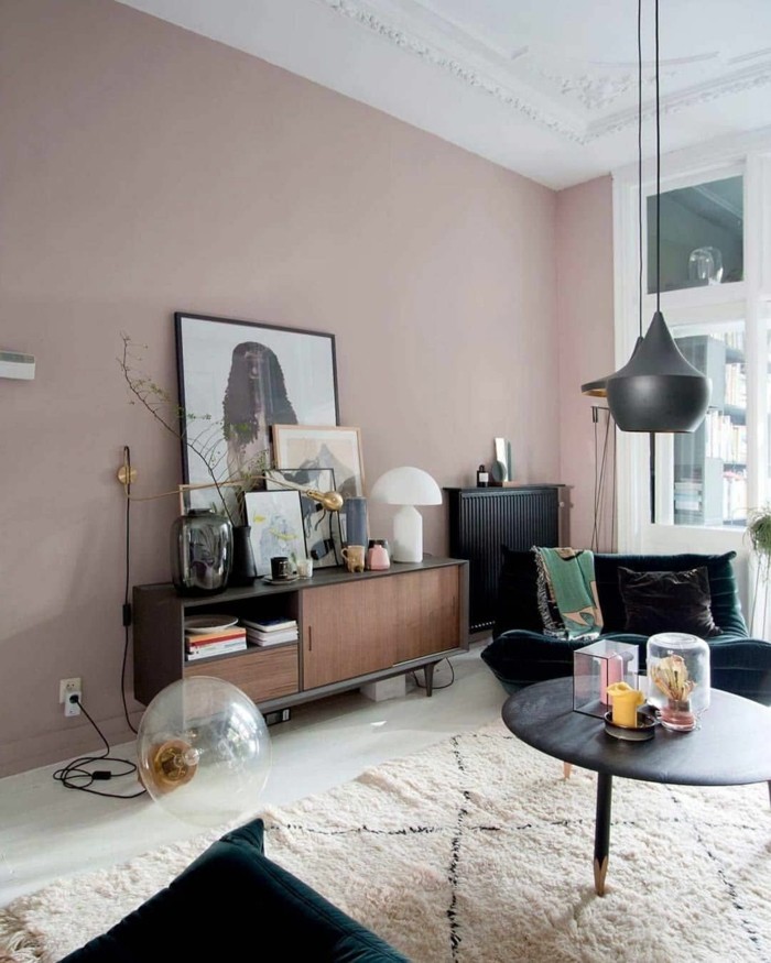 Farbe für Wand altrosa, moderne Ausstattung, weißer Teppich und schwarzer runder Tisch, Sessel in grün