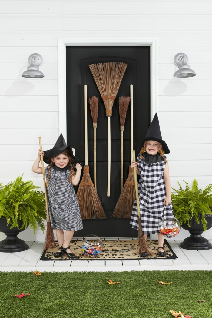 Hexenkostüme von zwei Mädchen in schwarze Kleider, schwarze Hütte und Besen, kinder faschingskostüme