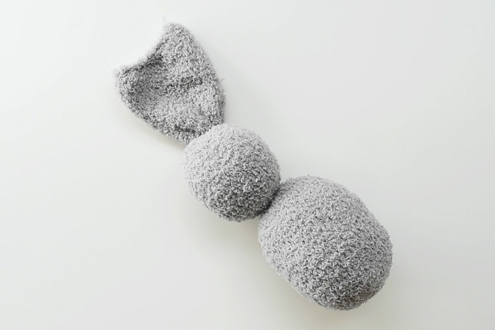 graue Socke gefüllt mit Watte in der Form eines Hasen, bastelideen zu Ostern, DIY Anleitung zum Basteln, Schritt für Schritt
