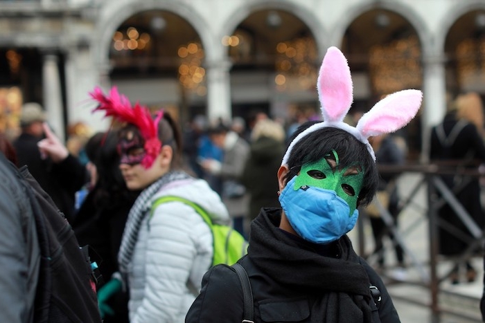 mann mit grüner maske mit langen weißen ohren, wegen coronavirus wird der diesjährige karneval in venedig abgesagt 
