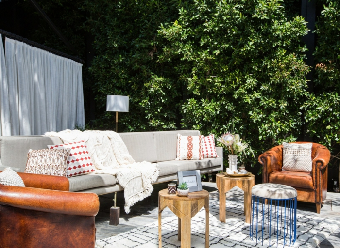 modische Einrichtung eines Gartens, großer grauer Couch, Sessel in Ziegelrot, weißer Teppich mit schwarzen Strichen, Gartengestaltung Ideen