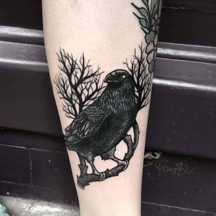 männer tattoo arm, schwarzer vogel am zweig, tätowierung mit rabe als motiv