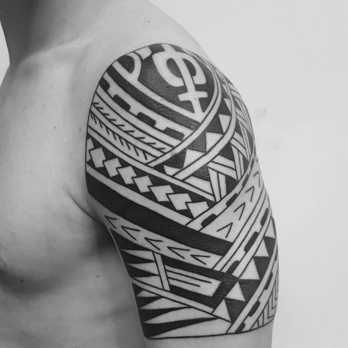 männer tattoos motive, mann mit blaackwork tätowierung an der schulter, maori elemente