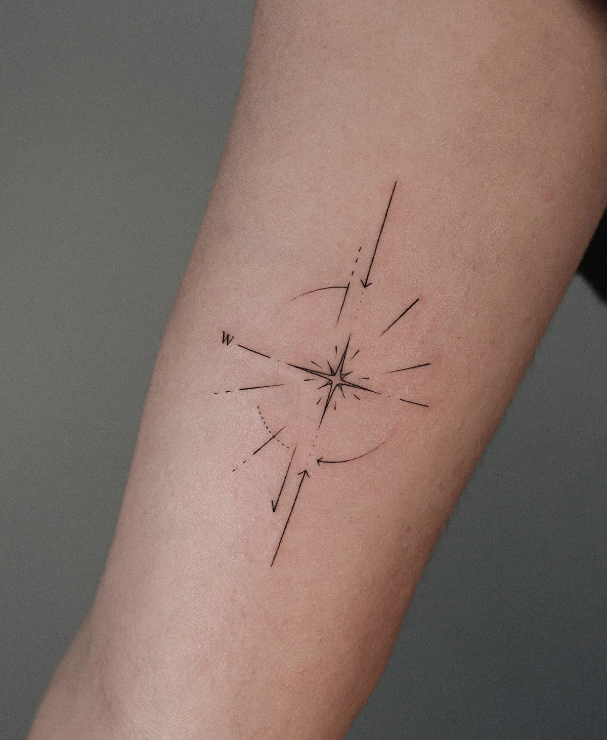 minimalistisches oberarm tattoo kompass motiv