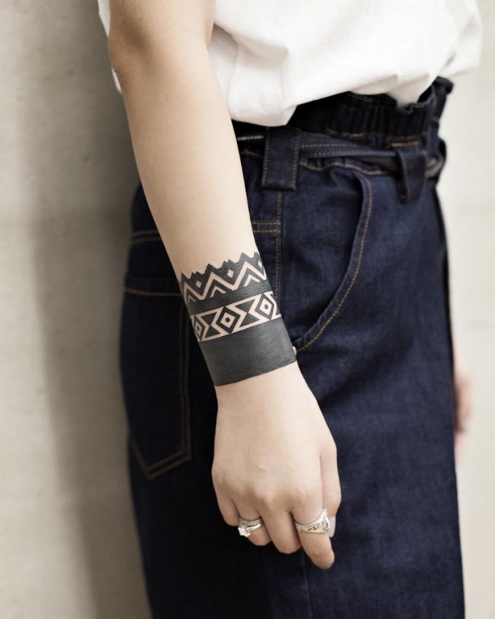 moderne tattoos für damen, tribal band am unterarm, geometrische elemente