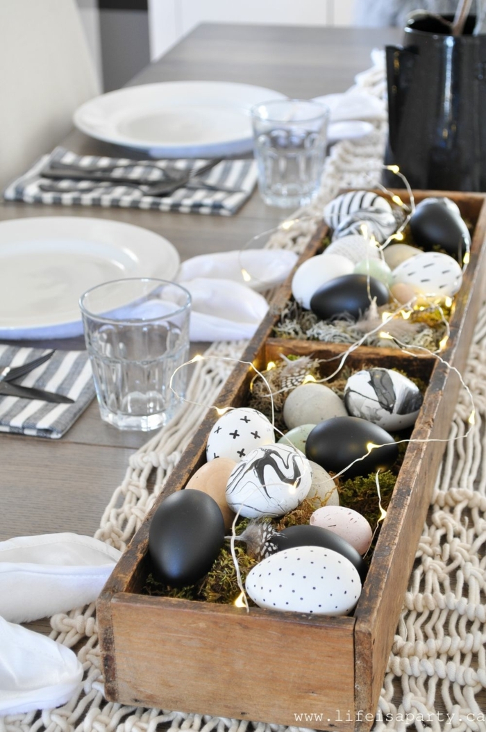 Tafelsufsatz von einem Holzkasten gefüllt mit Eier bemalt in verschiedenen Weisen, Osterdeko Holz, Servietten falten Ostern in Form von Osterhasenohren