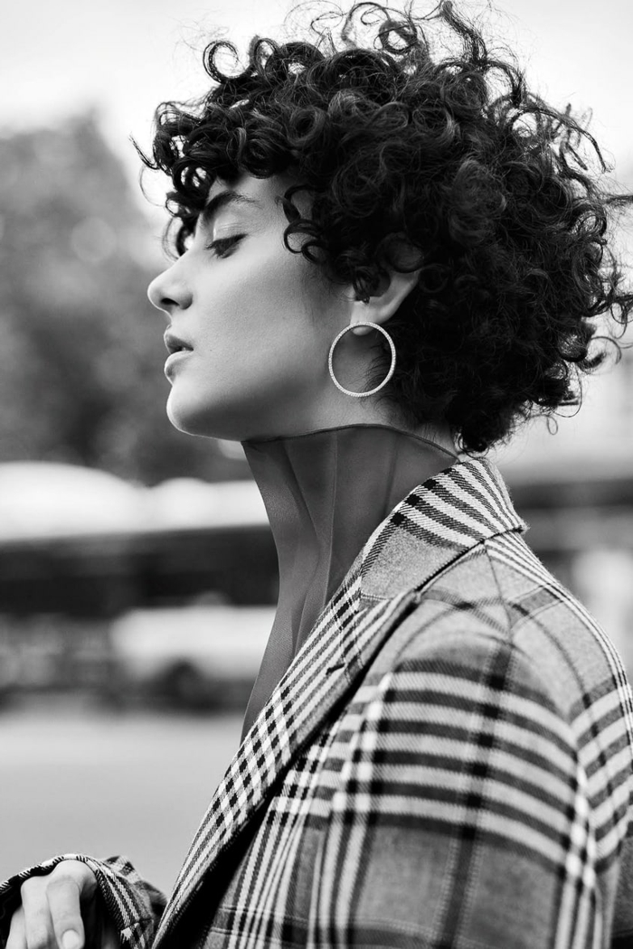 Schwarz weiße Fotografie von einer eleganten Frau, kurze dunkle Haare, moderne Kurzhaarfrisuren, karierter Mantel, kleine Kreolen