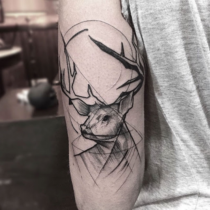 symbol für stärke, hirsch mit geometrischen motiven, oberarm tattoo in schwarz und grau