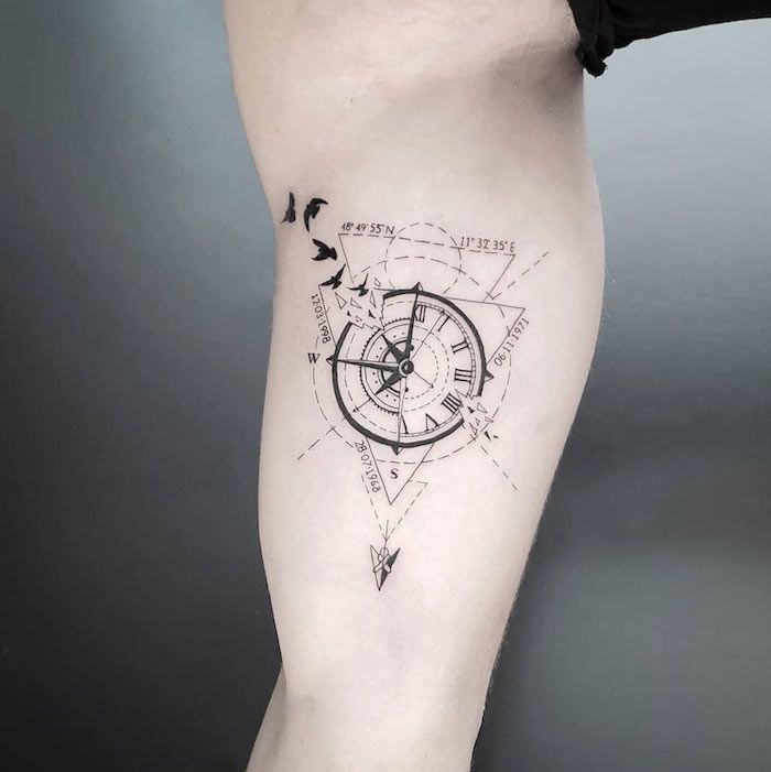 tattoo arm mann, kompass in kombiantion mit koordinaten und fliegenden vögeln