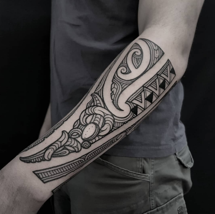 tattoo trends für herren, mann mit detaillierter tätpwierung am unterarm, symbole mit beudetung