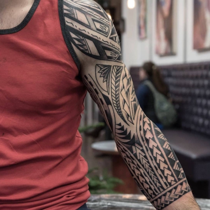 tattoo trends für männer, blackwork sleeve mit polynesichen motiven, geometrische tätowierung