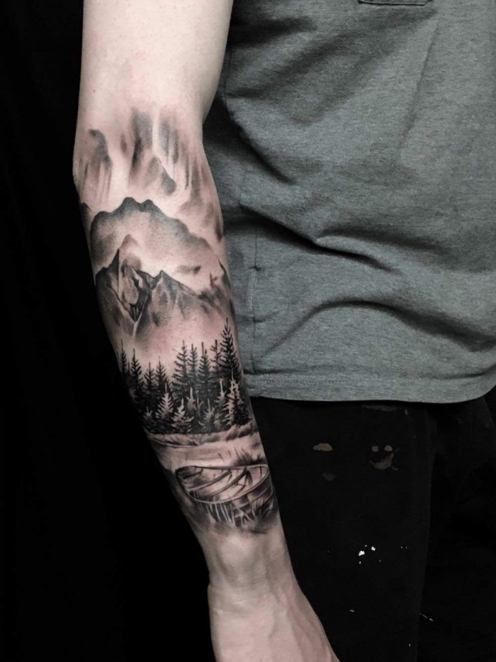 tattoo unterarm mann, schwarz graue tätowierung mit landschaft als motiv, gebirge, wald